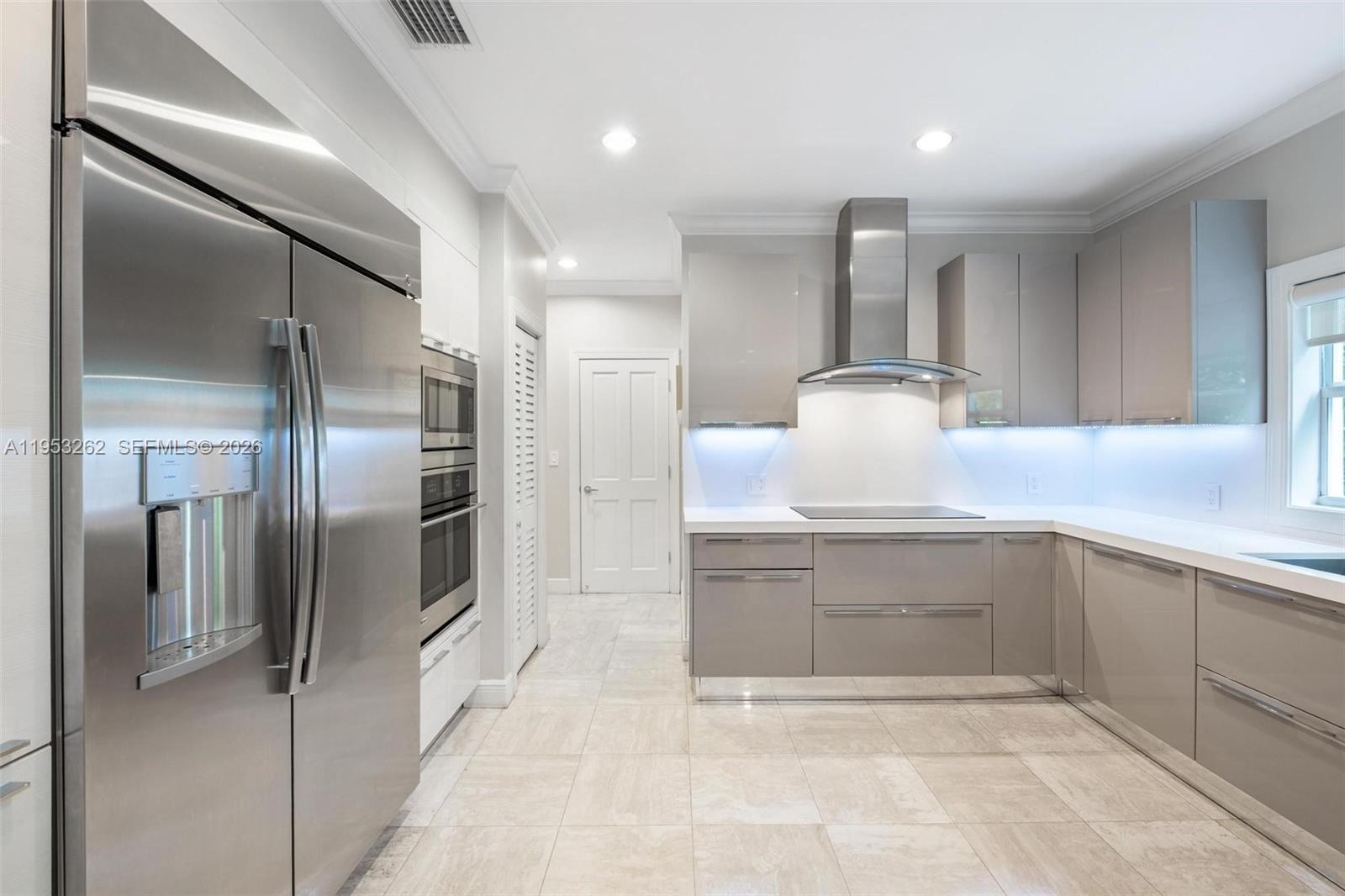 164 West Mashta Drive Key Biscayne, FL 33149 - Photo 11 of 34 a kitchen with stainless steel appliances kitchen island granite countertop a refrigerator and a sink