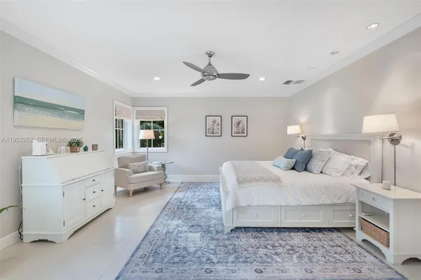 a spacious bedroom with a bed and ceiling fan