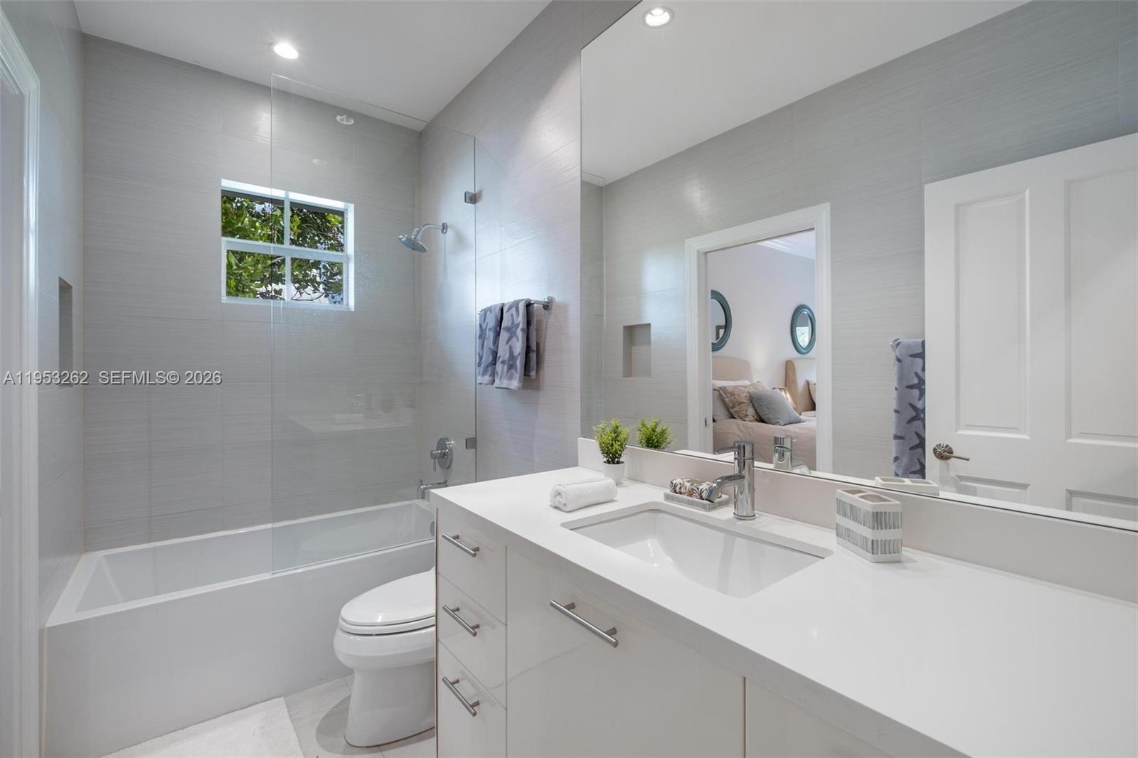 164 West Mashta Drive Key Biscayne, FL 33149 - Photo 25 of 34 a bathroom with a bathtub shower sink vanity mirror and toilet