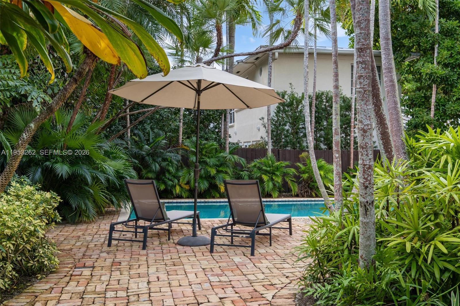164 West Mashta Drive Key Biscayne, FL 33149 - Photo 28 of 34 an outdoor view of patio with umbrella and garden