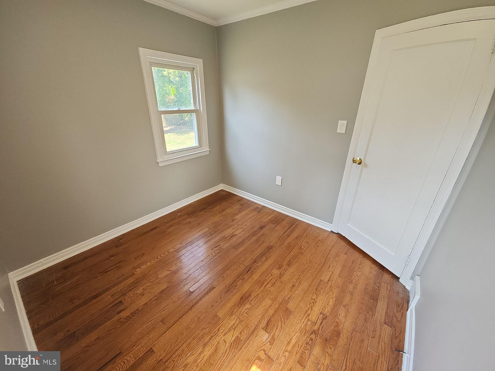 12024 Veirs Mill Road Silver Spring, MD 20906 - Photo 7 of 22 a view of an empty room with wooden floor and a window