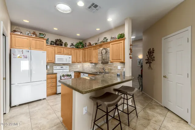 a kitchen with stainless steel appliances granite countertop a refrigerator and a stove top oven