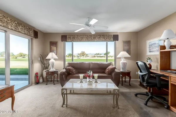 a living room with furniture a table and a large window