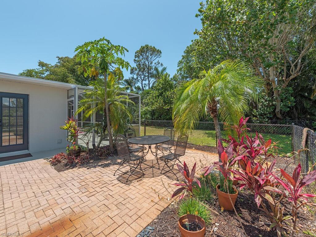 1471 Mandarin Road Naples, FL 34102 - Photo 22 of 28 a view of a backyard with potted plants and large trees