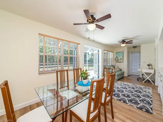 a dining room with furniture window and wooden floor