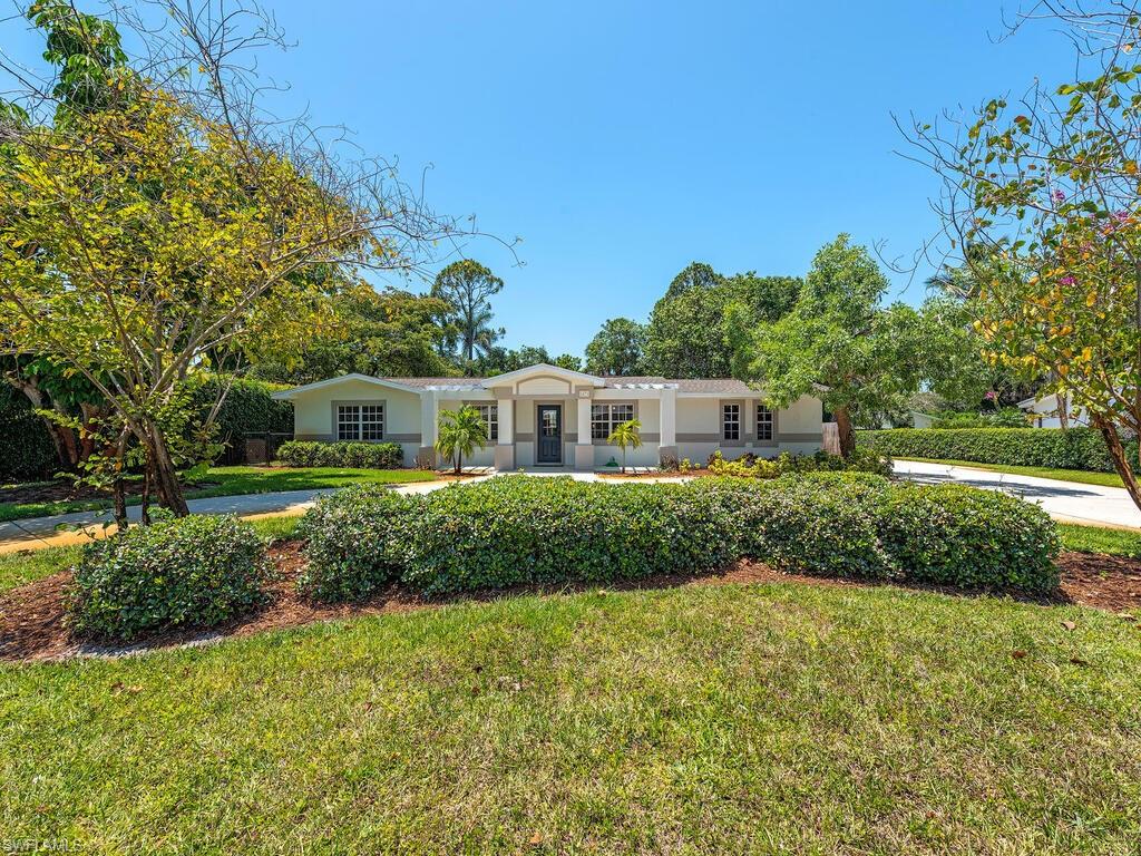 1471 Mandarin Road Naples, FL 34102 - Photo 5 of 28 a front view of a house with a yard