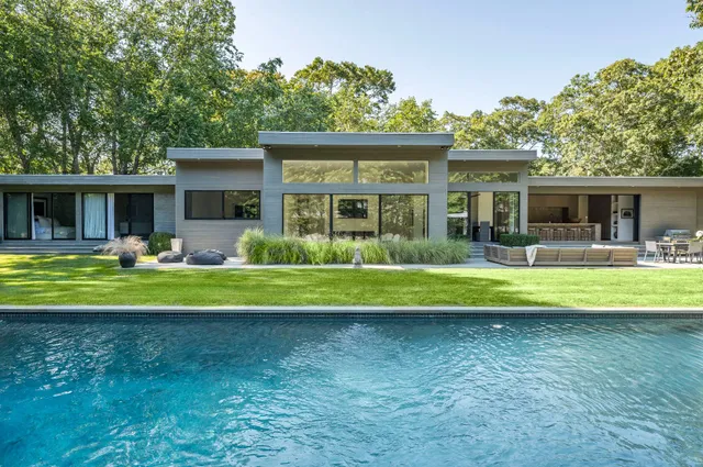a front view of house with outdoor seating and green space