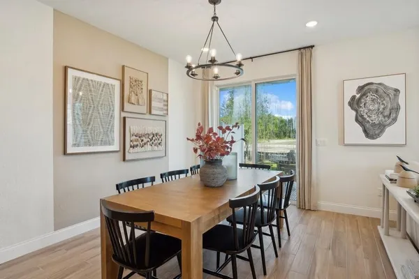 a dining room with furniture a chandelier and wooden floor