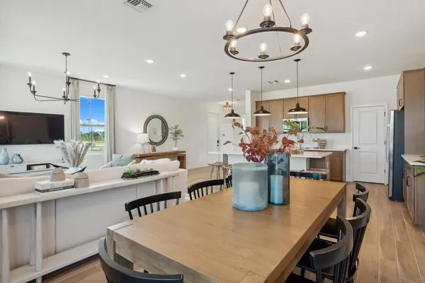 a kitchen with a dining table chairs stainless steel appliances and cabinets
