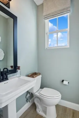 a bathroom with a toilet a sink and mirror
