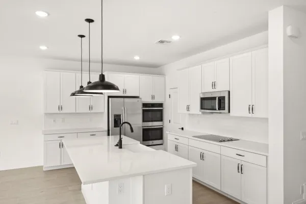 a kitchen with kitchen island a counter space a sink appliances and cabinets
