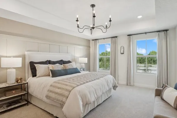 a spacious bedroom with a bed ceiling fan and a window