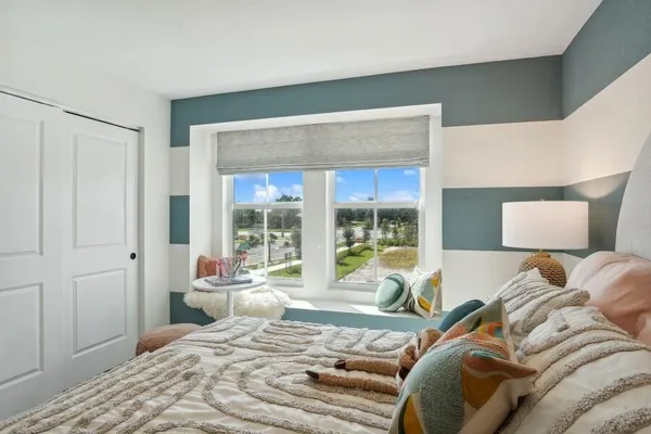 a bedroom with a bed and a large window