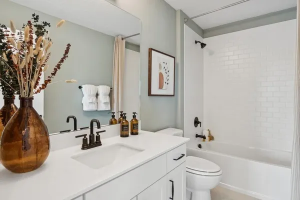 a bathroom with a sink mirror vanity and toilet