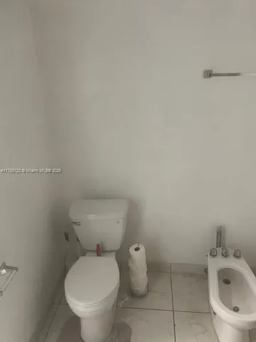 a white toilet sitting next to a white sink