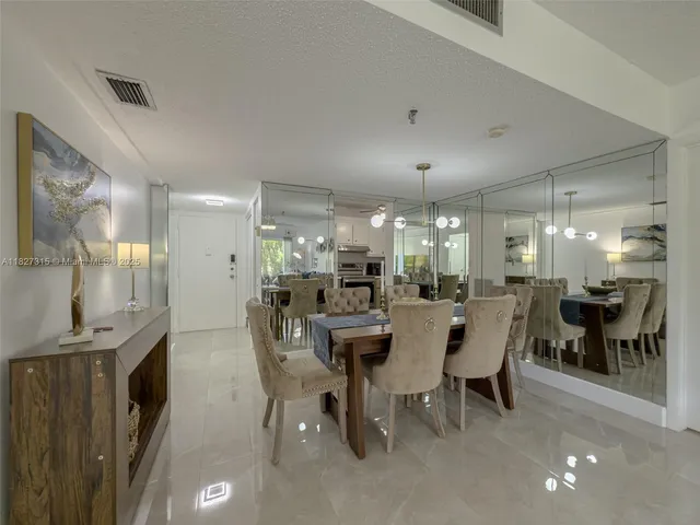 a dining room with stainless steel appliances kitchen island granite countertop a table and chairs