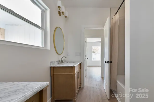 a bathroom with a granite countertop sink a mirror a vanity and a shower
