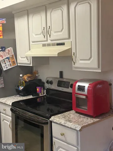 a kitchen with granite countertop a stove and a microwave
