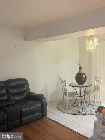 a living room with furniture a dining table and a chandelier
