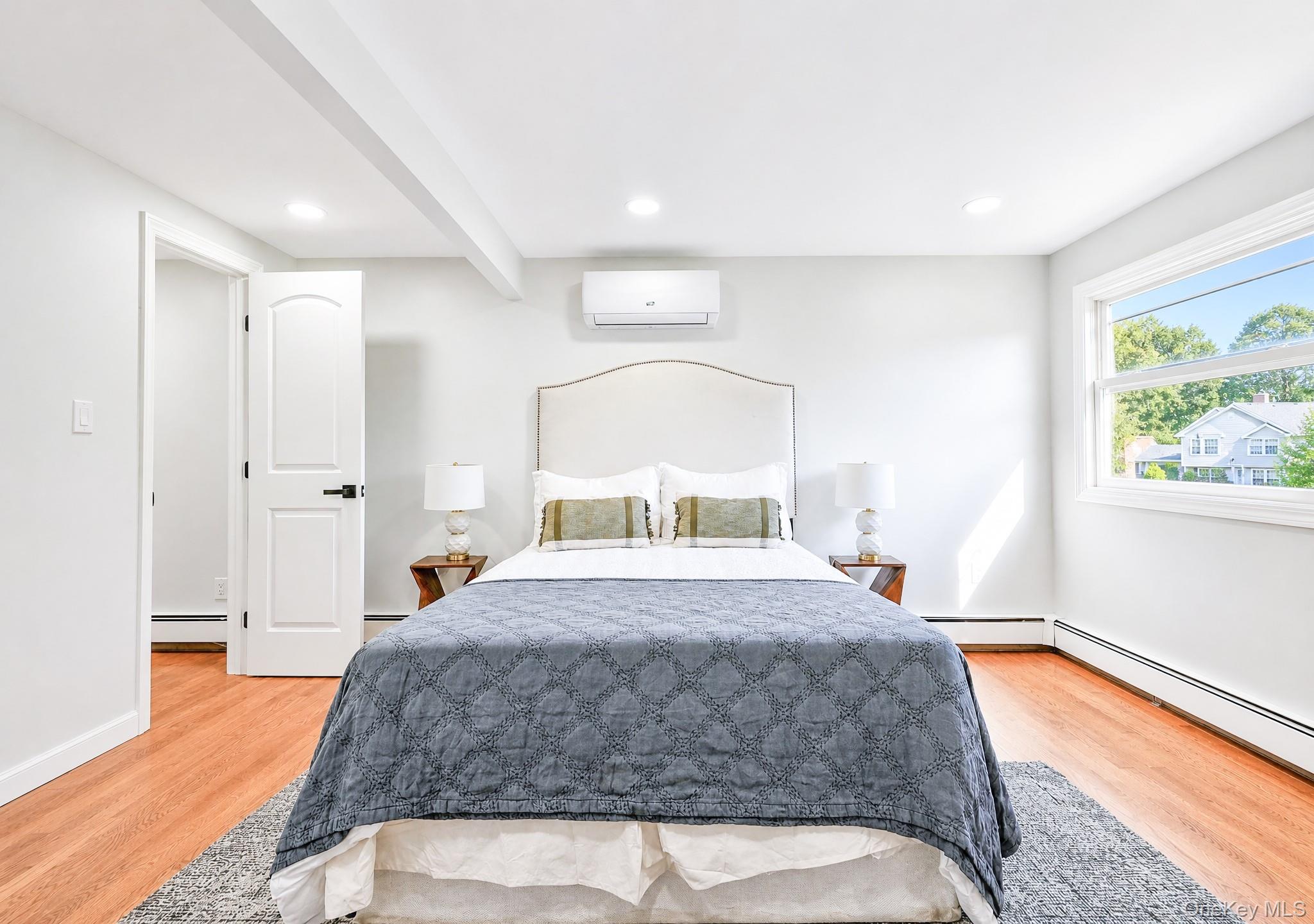 61 Cheshire Road Bethpage, NY 11714 - Photo 19 of 25 Bedroom featuring wood-finish flooring and a bright window