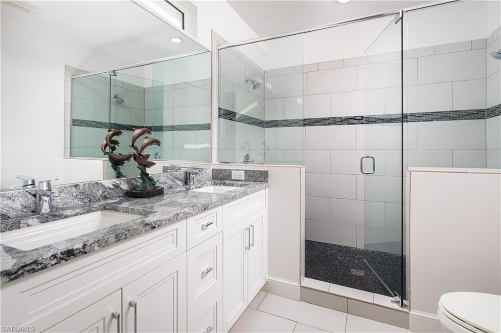 451 Oak Avenue Naples, FL 34108 - Photo 11 of 25 a bathroom with a granite countertop sink a mirror and shower