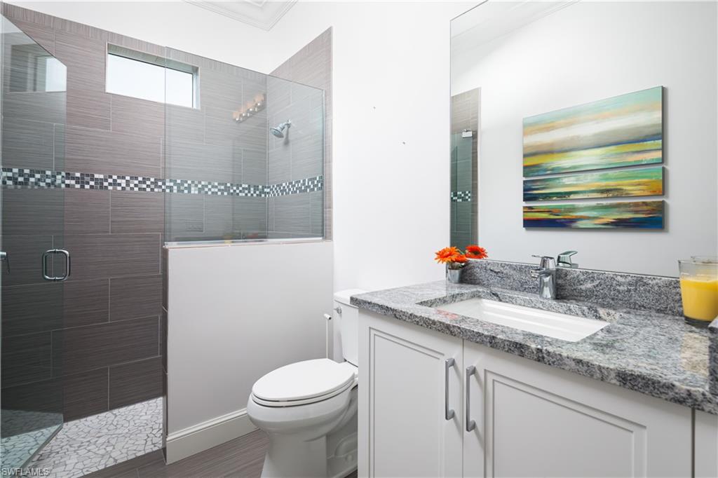 451 Oak Avenue Naples, FL 34108 - Photo 17 of 25 a bathroom with a granite countertop sink a toilet and a mirror