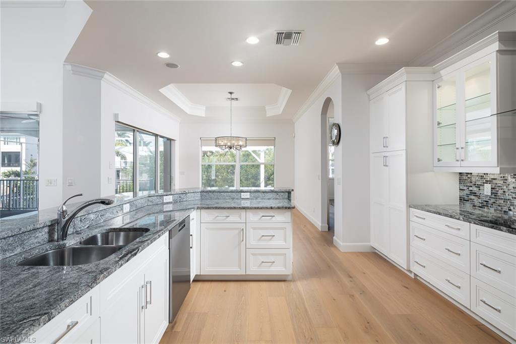 451 Oak Avenue Naples, FL 34108 - Photo 6 of 25 a large kitchen with granite countertop a large counter top a sink stainless steel appliances and cabinets