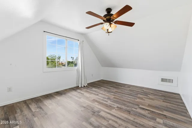 an empty room with a window and a ceiling fan