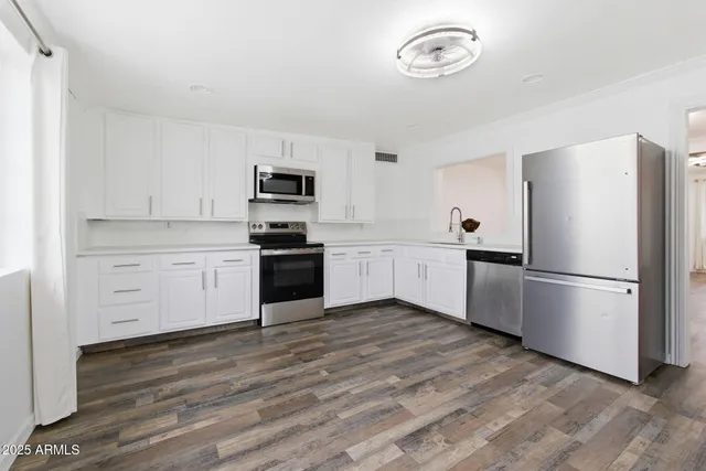 a kitchen with a refrigerator stove and white cabinets