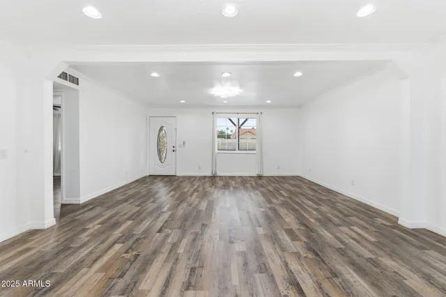 a view of empty room with wooden floor
