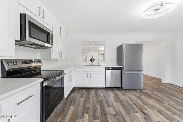 a kitchen with granite countertop a sink a stove top oven and refrigerator