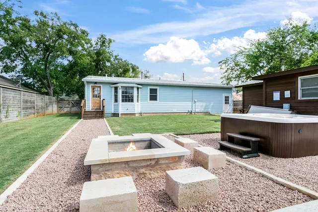 a view of a house with backyard sitting area and garden