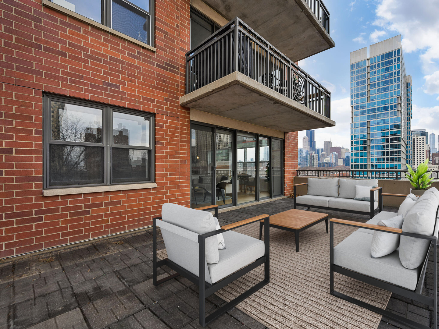 5 East 14th Place, Unit 501 Chicago, IL 60605 - Photo 21 of 26 a view of a patio with couches table and chairs and potted plants