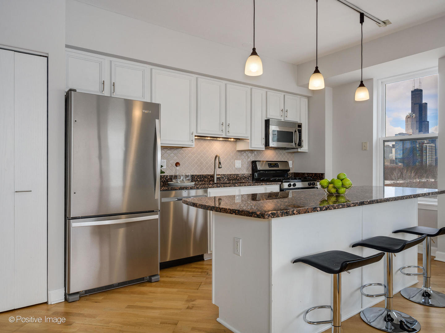 5 East 14th Place, Unit 501 Chicago, IL 60605 - Photo 3 of 26 a kitchen with granite countertop a refrigerator a stove a microwave and island with wooden floor