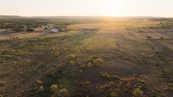 an aerial view of residential houses with outdoor space and trees