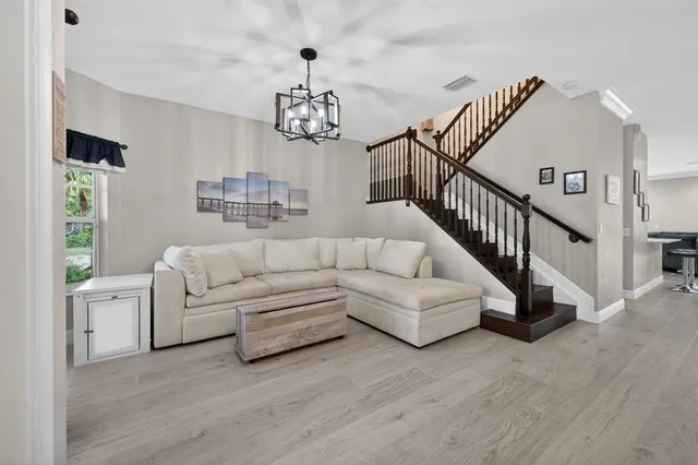 a living room with furniture and a chandelier