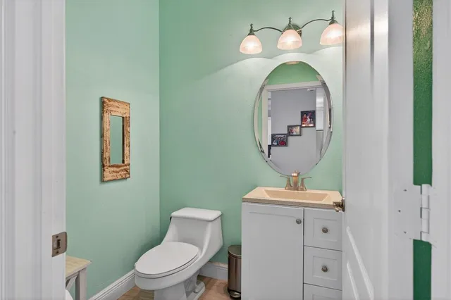 a bathroom with a toilet sink and mirror