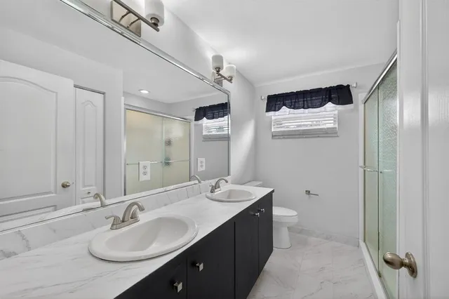a bathroom with a double vanity sink and mirror