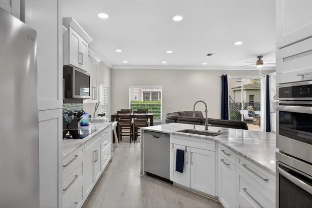a kitchen with white cabinets and appliances