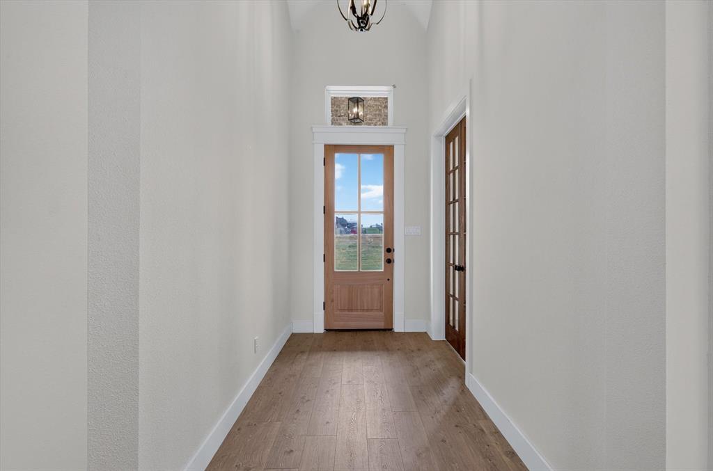 471 Red Bird Drive Springtown, TX 76082 - Photo 4 of 35 Entryway featuring vaulted ceilings, wood-finish flooring, and a natural wood front door with glass panels