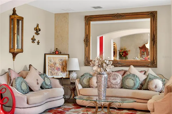 a living room with furniture and a mirror
