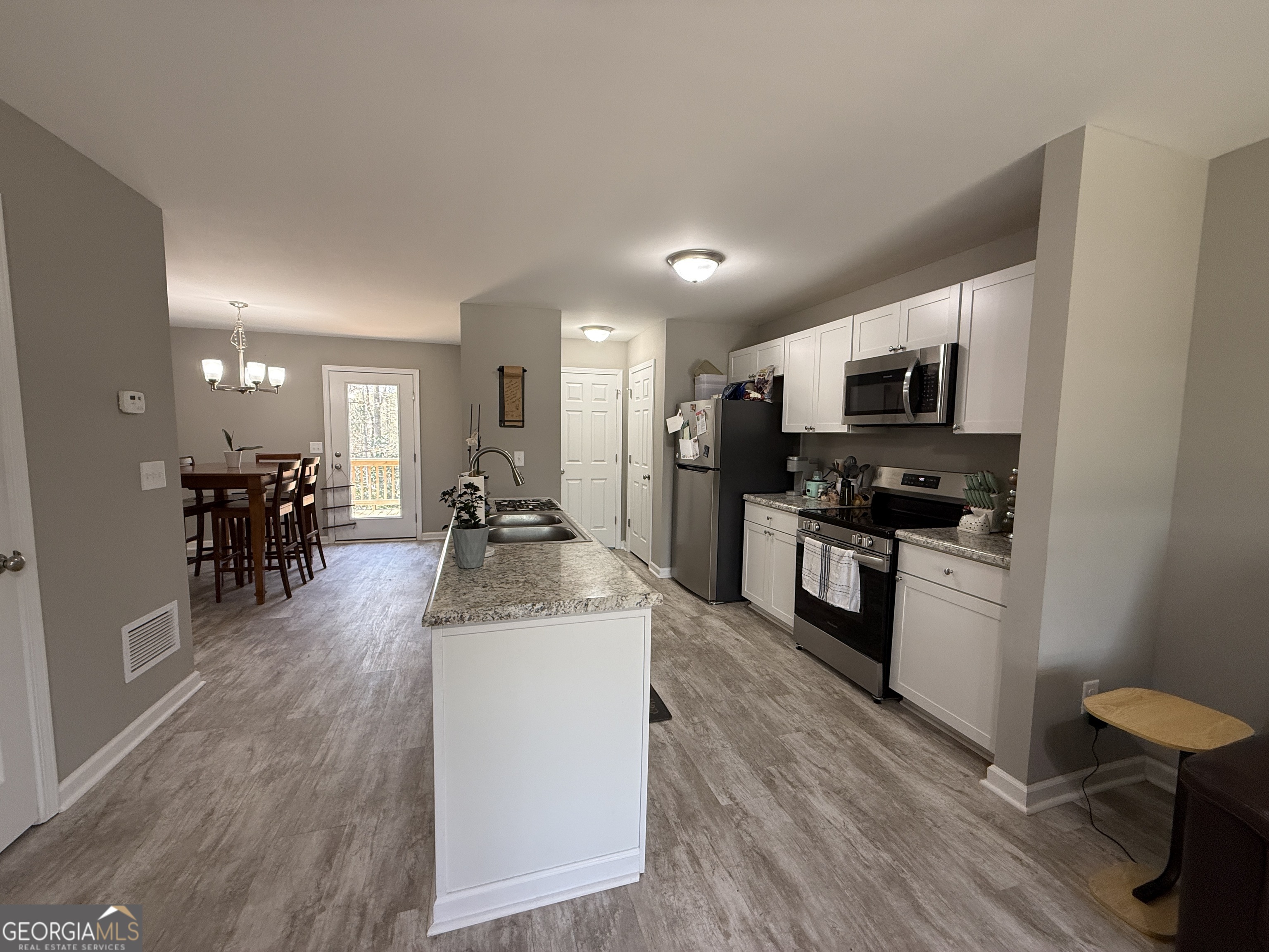 305 Martin Circle Athens, GA 30601 - Photo 3 of 15 a large kitchen with kitchen island a sink and a stove top oven with wooden floor