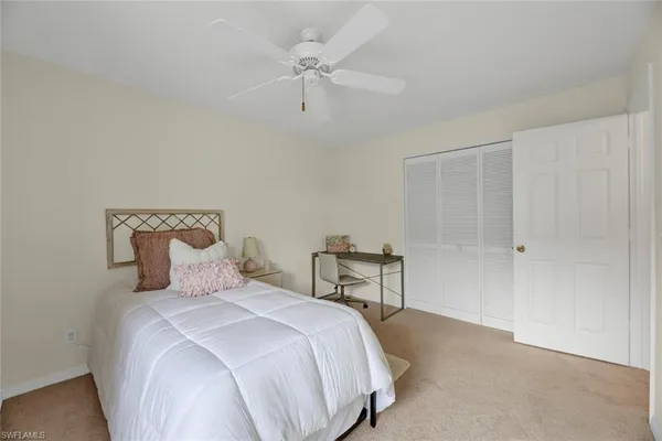 a bedroom with a bed and a ceiling fan