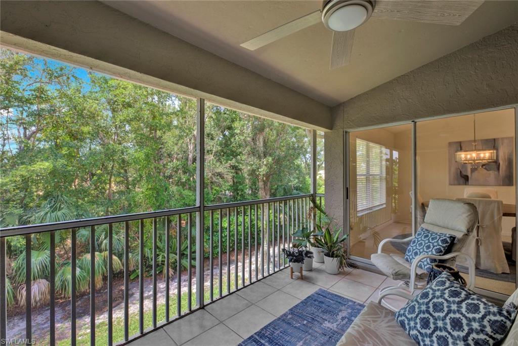 386 Emerald Bay Circle, Unit G4 Naples, FL 34110 - Photo 18 of 20 a balcony with furniture and wooden floor