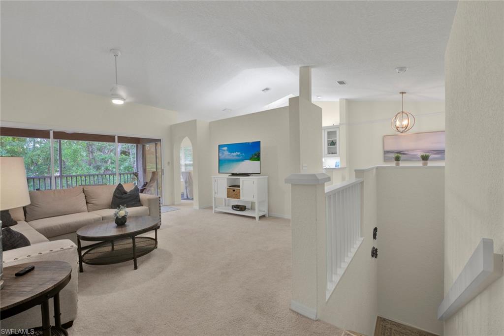 386 Emerald Bay Circle, Unit G4 Naples, FL 34110 - Photo 2 of 20 a living room with furniture and a large window