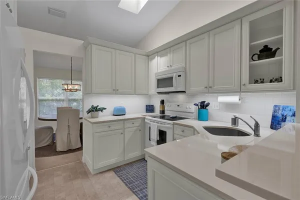 a kitchen with cabinets appliances a sink and a counter top space
