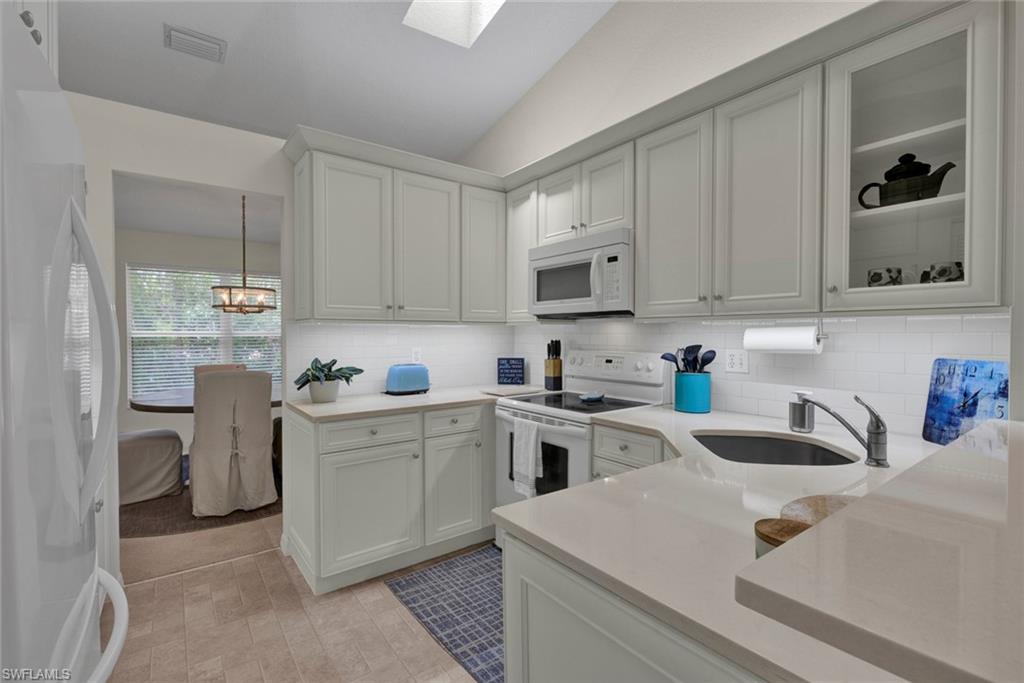 386 Emerald Bay Circle, Unit G4 Naples, FL 34110 - Photo 6 of 20 a kitchen with cabinets appliances a sink and a counter top space