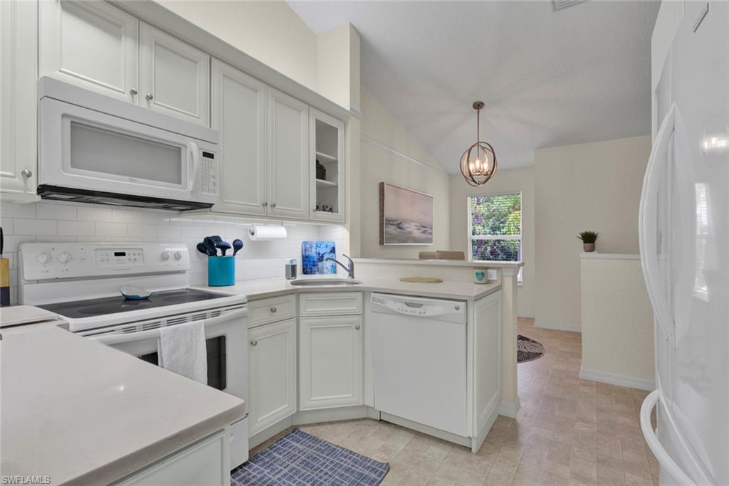 386 Emerald Bay Circle, Unit G4 Naples, FL 34110 - Photo 7 of 20 a kitchen with white cabinets and sink