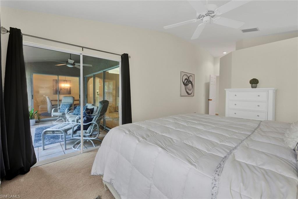 386 Emerald Bay Circle, Unit G4 Naples, FL 34110 - Photo 9 of 20 a bedroom with a bed and large windows