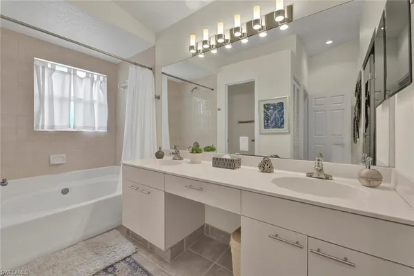 a bathroom with a sink double vanity granite tub and a mirror